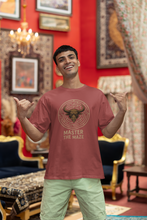 Man wearing a red t-shirt with a bull graphic and text, standing in an ornate room.