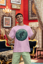 Man wearing a pink t-shirt with a graphic design in a decorated room.