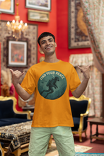 Man wearing a yellow t-shirt with a graphic design in a decorated room.