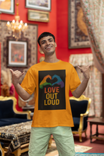 Man wearing a yellow t-shirt with 'Love Out Loud' design in a decorated room.