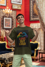 Man wearing a t-shirt with 'Love Out Loud' design in a decorated room.
