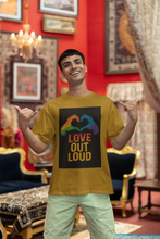 Man wearing a yellow t-shirt with 'Love Out Loud' design in a decorated room.