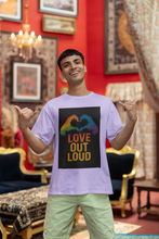 Man wearing a t-shirt with 'Love Out Loud' design in a decorated room.
