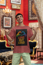 Man wearing a t-shirt with 'Love Out Loud' design in a decorated room.
