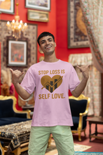 Man wearing a pink t-shirt with a heart and text design, standing in an ornate room.
