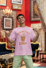 Man wearing a pink t-shirt with a humorous design in an ornate room.