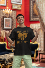 Man wearing a black t-shirt with a gold message in a decorated room.