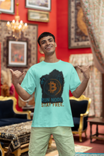 Man wearing a light blue t-shirt with Bitcoin design and text in a decorated room.