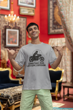 Man wearing a t-shirt with a motorcycle graphic and text in a decorated room.