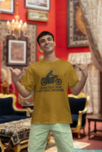 Man wearing a yellow t-shirt with a motorcycle graphic and text, standing in an ornate room.