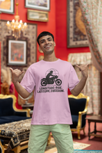 Man wearing a pink t-shirt with a graphic design and text, standing in an ornate room.
