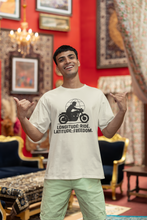 Man wearing a t-shirt with a motorcycle graphic and text in a decorated room.