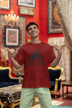 Man wearing a red t-shirt with a graphic design in a decorated room.