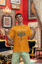 Man wearing an orange t-shirt with a circus-themed design in a decorated room.