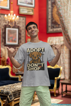 Man wearing a t-shirt with an 'Adopt Don't Shop' graphic in a decorated room.