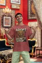 Man wearing a t-shirt with an 'Adopt Don't Shop' graphic in a decorated room.