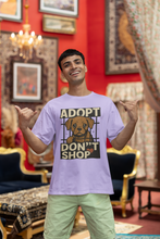 Man wearing a shirt with an 'Adopt Don't Shop' graphic in a decorated room.