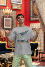 Man wearing a t-shirt with 'Embrace Transformation' graphic in a decorated room.