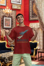 Man wearing a red t-shirt with a graphic and text, standing in an ornate room.
