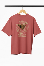 Red t-shirt with bull and maze graphic on a hanger against a white background
