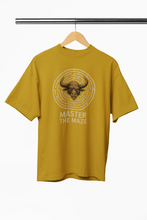 Yellow t-shirt with bull graphic and 'Master the Maze' text on a hanger against a white background