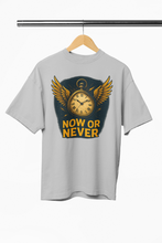 Gray t-shirt with a clock and wings graphic and 'NOW OR NEVER' text on a hanger.