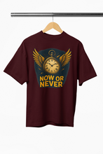 Maroon t-shirt with a clock design and 'NOW OR NEVER' text on a hanger against a white background