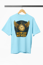Light blue t-shirt with a clock and wings graphic and 'NOW OR NEVER' text on a hanger.