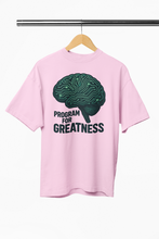 Pink t-shirt with brain graphic and 'Program for Greatness' text on a hanger.