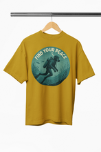 Yellow t-shirt with a graphic of a diver and 'Find Your Peace' text on a hanger against a white background