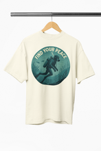 Beige t-shirt with 'Find Your Peace' graphic on a hanger against a white background