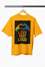 Yellow t-shirt with 'Love Out Loud' graphic on a hanger against a white background