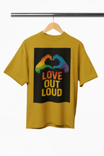 Mustard yellow t-shirt with 'Love Out Loud' graphic on a hanger against a white background