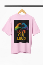 Pink t-shirt with 'Love Out Loud' graphic on a hanger against a white background