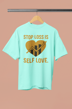 Mint green t-shirt with motivational graphic and text on a hanger against a beige background