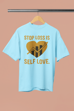 Light blue t-shirt with a graphic and text on a hanger against a beige background