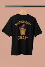 Black t-shirt with yellow text and graphic on a beige background