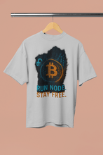 Gray t-shirt with Bitcoin logo and text on a hanger against a beige background