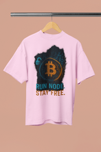 Pink t-shirt with Bitcoin logo and text on a hanger against a beige background