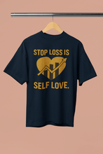 Black t-shirt with gold text and graphic on a beige background