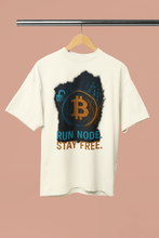 White t-shirt with Bitcoin logo and text on a hanger against a beige background