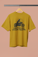 Yellow t-shirt with motorcycle graphic and text on a hanger against a beige background