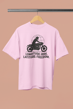 Pink t-shirt with a graphic and text on a hanger against a beige background