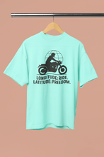 Mint green t-shirt with motorcycle graphic and text on a hanger against a beige background