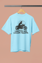 Light blue t-shirt with motorcycle graphic and text on a hanger against a beige background