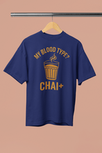 Blue t-shirt with yellow text and graphic on a hanger against a beige background