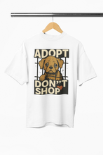 White t-shirt with a dog graphic and 'Adopt Don't Shop' text on a hanger.