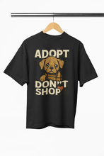 Black t-shirt with a dog graphic and 'ADOPT DON'T SHOP' text on a hanger.