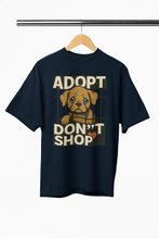 Black t-shirt with 'ADOPT DON'T SHOP' text and dog graphic on a hanger.