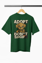 Green t-shirt with 'ADOPT DON'T SHOP' text and dog graphic on a hanger.